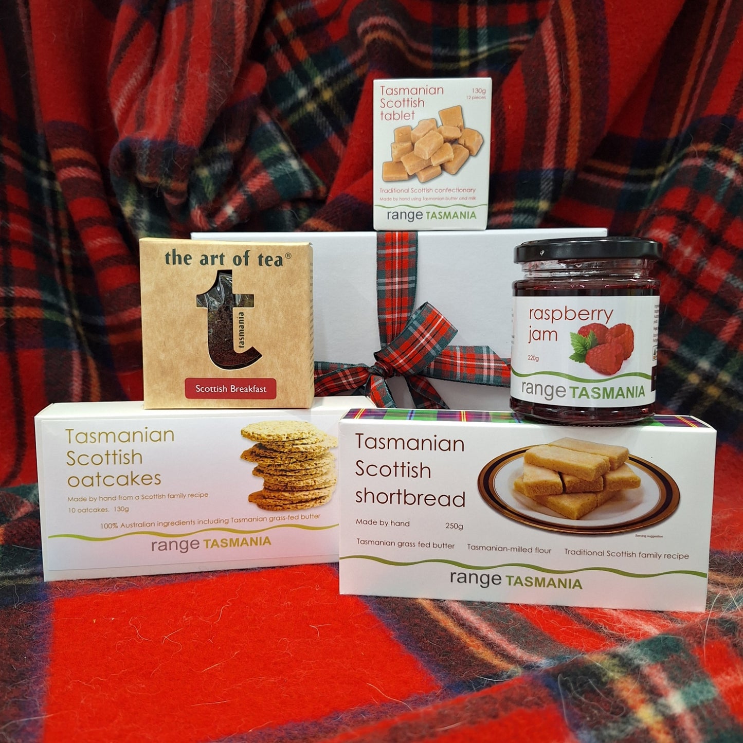 Assorted food products including jam, shortbread, and oatcakes on a plaid fabric background