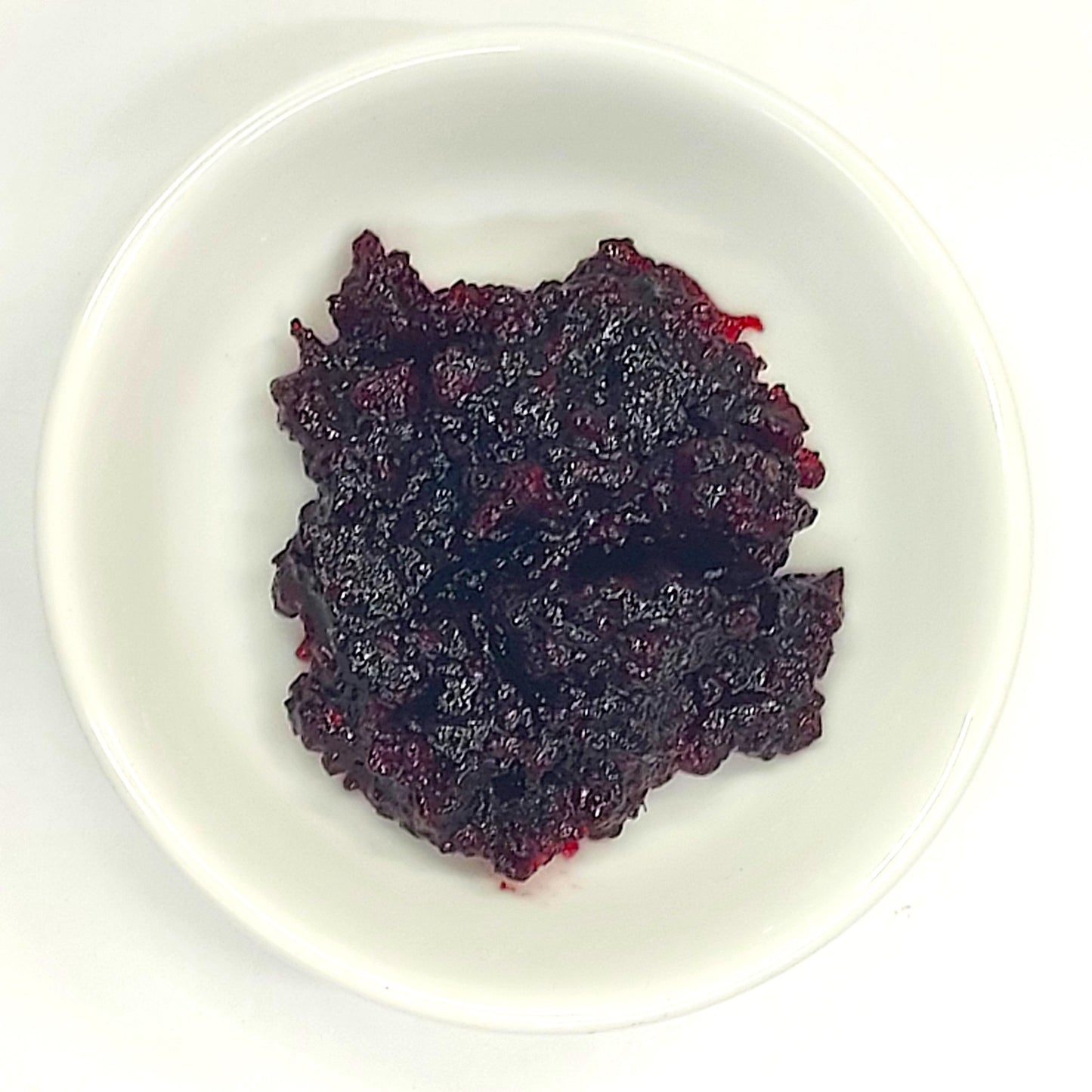 white bowl with range tasmanian sylvanbery jam in it" Improved: "Silvanberry jam served in white ceramic bowl showing rich purple color and chunky berry texture