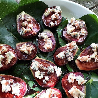 Elderberry vinegar drizzled over leafy green salad with fresh figs and feta cheese