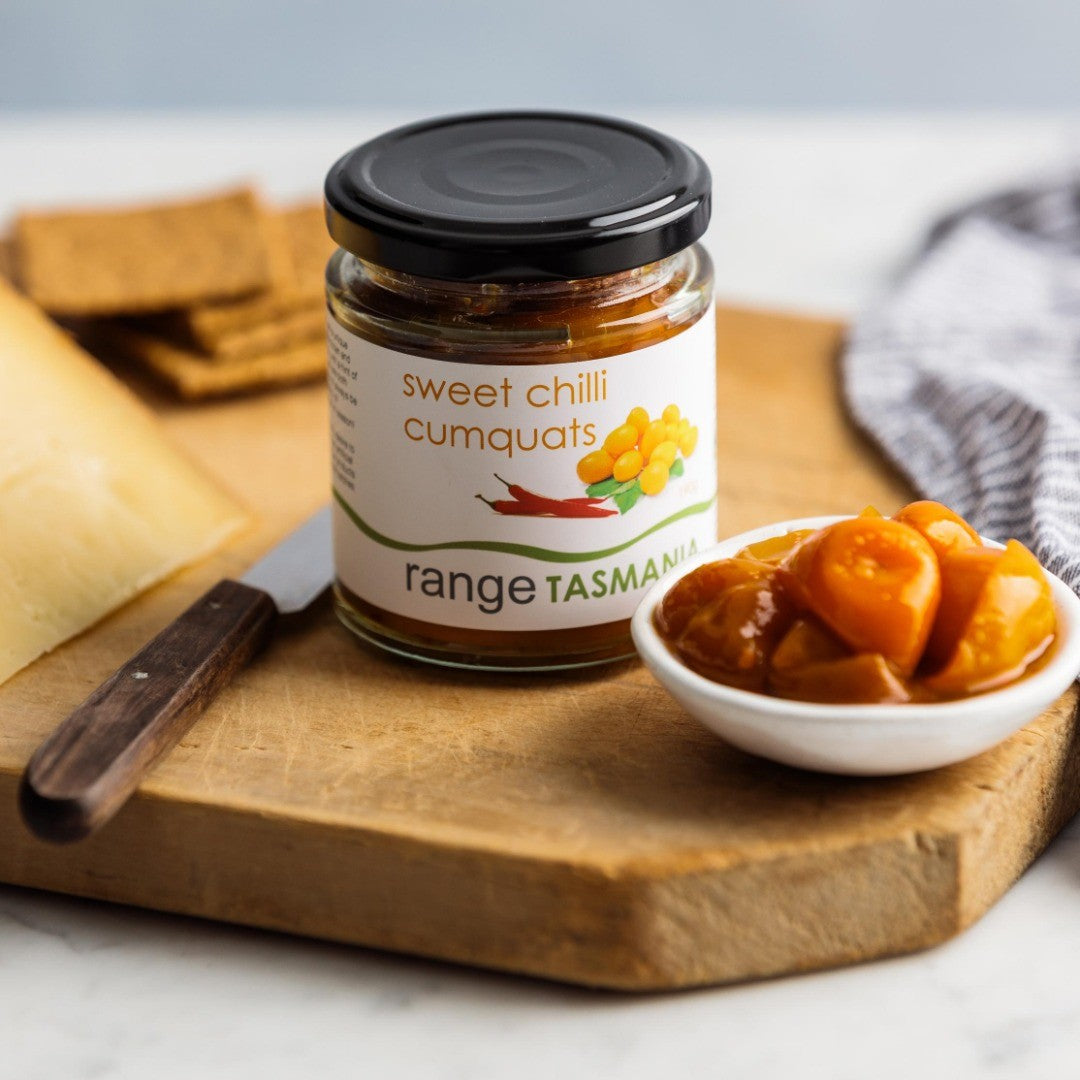range Tasmania sweet chilli cumquats served with bruny island cheddar cheese and crackers on wooden board