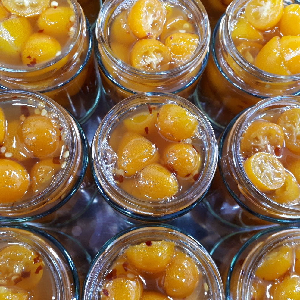 line up of freshy cooked and jars of range Tasmania sweet chilli cumquats