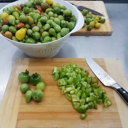 green tomatoes being chopped on wooden board